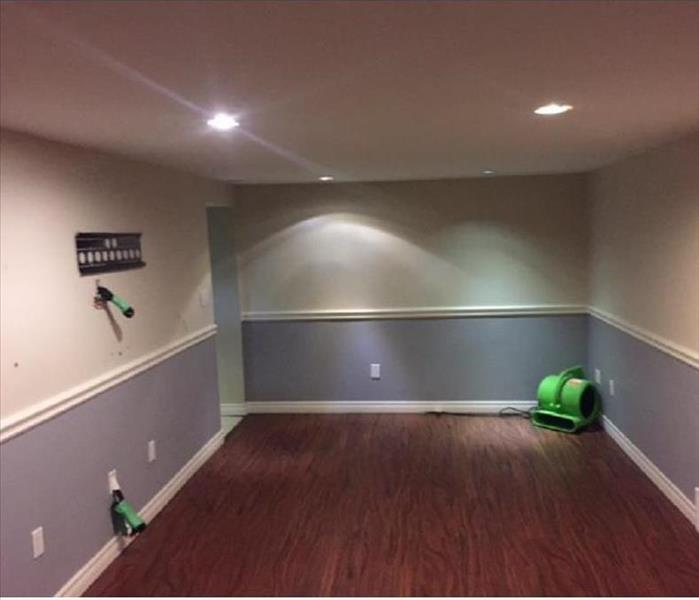 Empty room with two paint colours on walls and laminate floor 