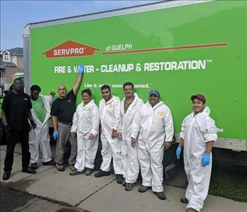 8 people standing against a SERVPRO vehicle 