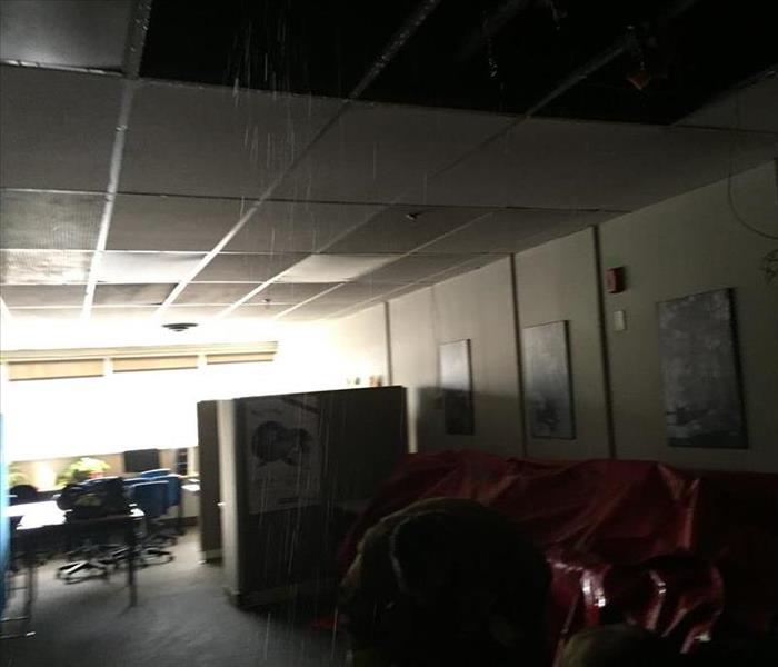 Water dripping down on ceiling tiles in this office 